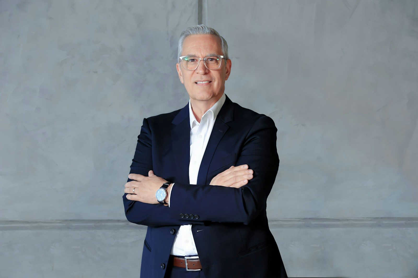 a man in a suit standing with his arms crossed
