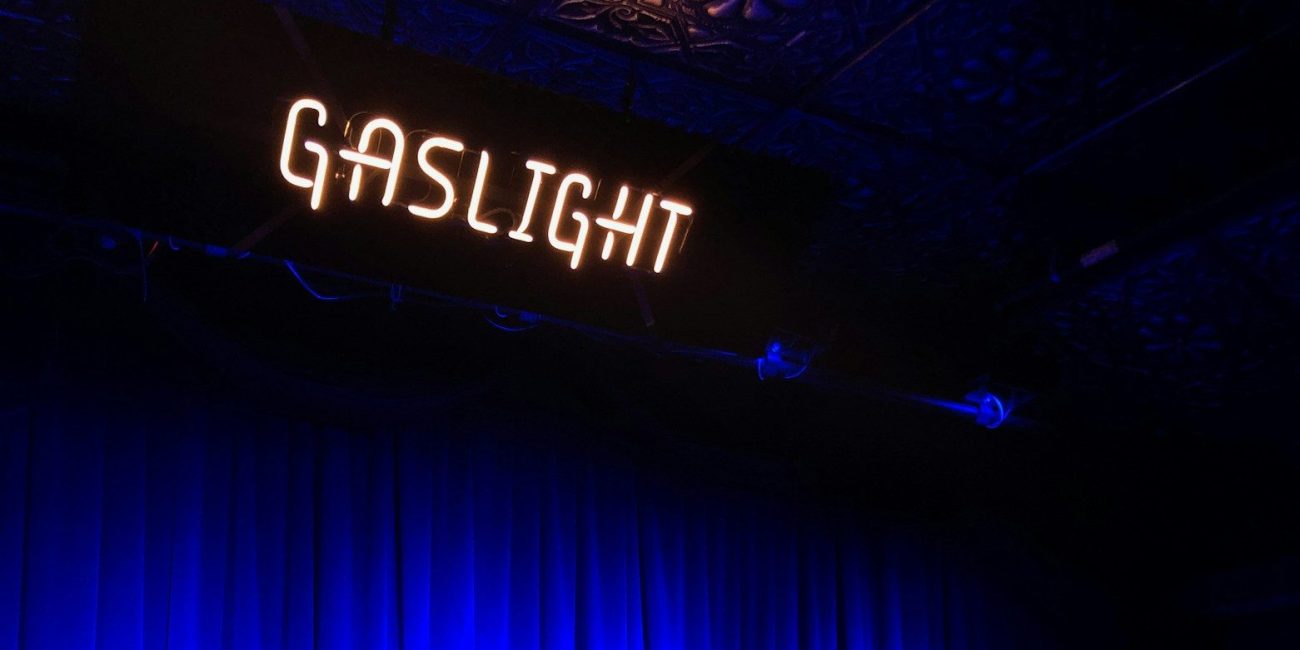 a stage with a blue curtain and a sign that reads gaslight