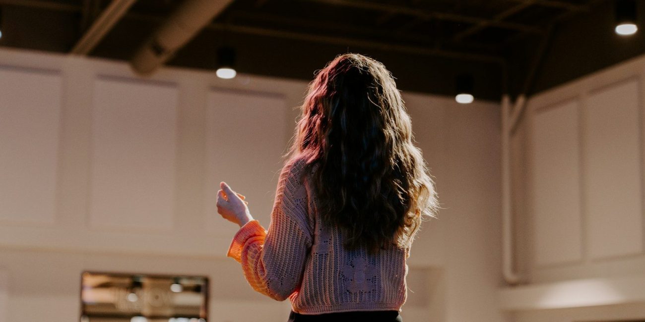a woman standing in a room holding a remote