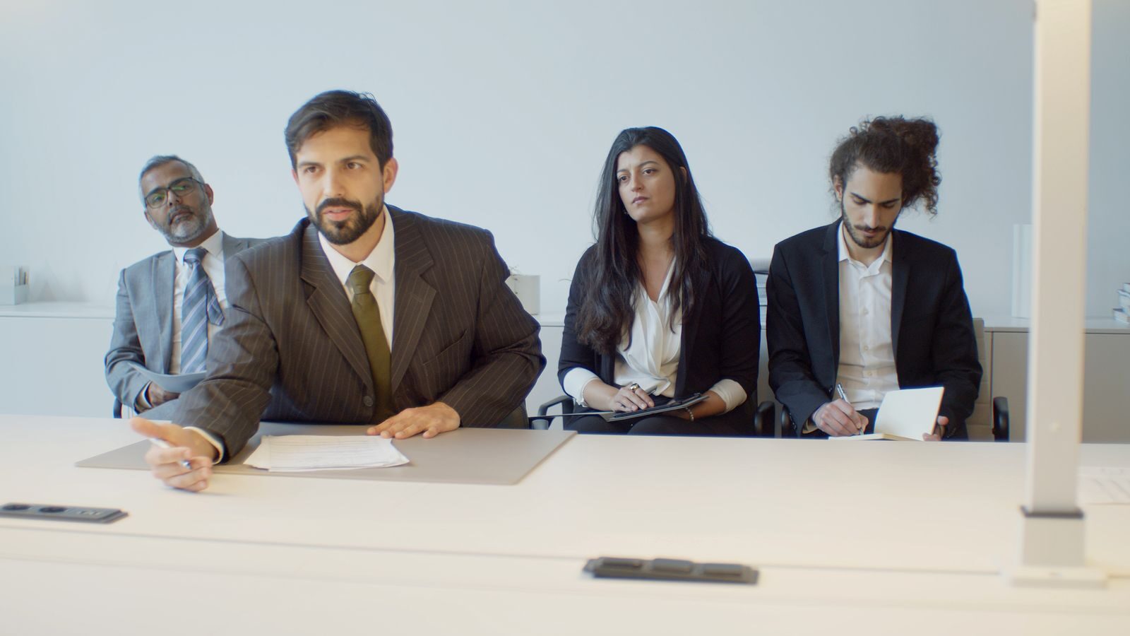 A diverse group of business professionals in a modern office setting, focusing on teamwork.